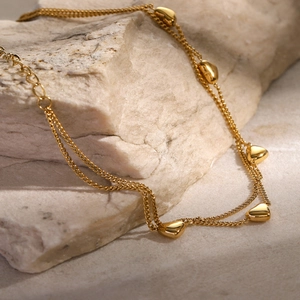 Detail view of 16k gold plated double-layer stainless steel anklet with heart charms