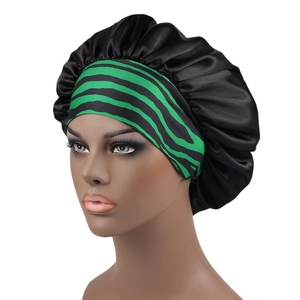 Detail view of the black satin hair bonnet with green striped elastic band on a model