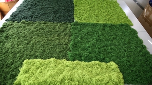 Close-up of assorted artificial silk moss samples in various shades of vibrant green