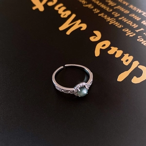 Detail of vintage silver adjustable ring with grey cat-eye stone and zircon halo