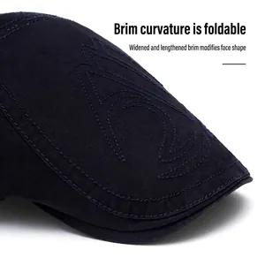 Dark blue cotton flat cap with decorative embroidery and a wide curved brim