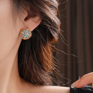 Close-up of vintage gold-plated enamel flower earrings with intricate zircon detailing
