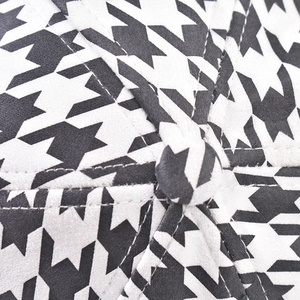Macro detail of houndstooth baseball cap crown featuring high-quality stitching and top button