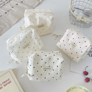 Detailed view of four striped heart makeup bags with colorful heart patterns and ribbons