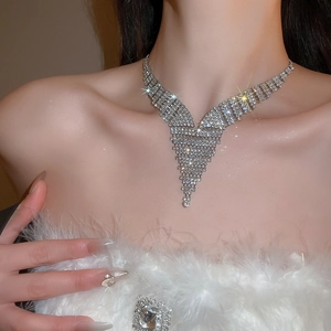Detailed close-up of sparkling V-shape silver rhinestone necklace and matching brooch