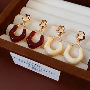 Retro oval resin earrings with gold pleated metal accents in burgundy and cream white