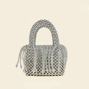 Detailed view of silver beaded basket bag with handmade fringes and woven texture
