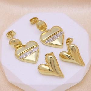 Elegant gold-plated heart-shaped earrings with zircon accents on a marble hexagonal base