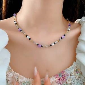 Close-up of a multi-colored beaded pearl necklace worn on a woman neck for styling