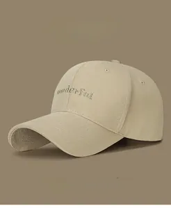 Close-up of golden embroidery on khaki cotton baseball cap showing fine stitching detail