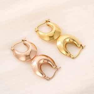 Detailed view of chunky U-shaped hoop earrings in polished gold and rose gold finishes