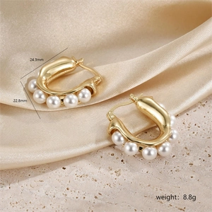 Macro shot of U-shaped gold earrings with five white pearls showing dimensions 24.3mm and 8.8g
