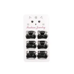Set of 6 mini black bow hair claws for girls displayed on a white fashion jewelry card