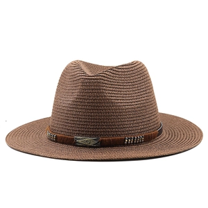 Détail d'un chapeau fedora en paille marron avec clous en métal et boucle en bronze