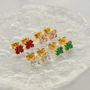 Détail de boucles d'oreilles trèfle à quatre feuilles en zircon sur un plateau