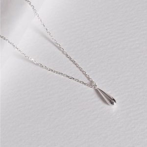 Macro shot of polished 925 sterling silver teardrop pendant and delicate link chain