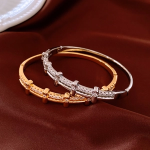 Détail de bracelets plaqués or 18 carats et argent avec zircons sur soie brune