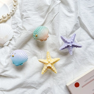 Macro detail of starfish and seashell phone grips with pearls on white fabric
