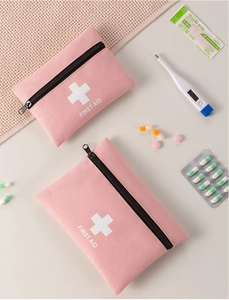 Detail of pink velvet first aid kits with white cross and medical supplies on white desk