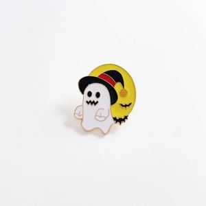 Detail of Halloween ghost enamel pin wearing witch hat with a yellow moon background