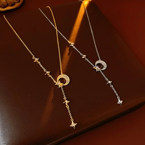 Detail of gold and silver Y-shaped tassel necklaces with zircon moon and star pendants