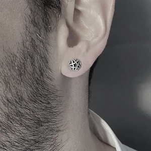 Silver hollow star stud earring for men in a vintage punk style worn on the earlobe