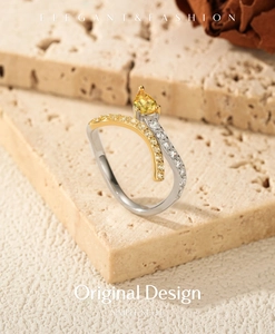 Detail of snake-style bicolor ring with pear-cut yellow zircon and pave setting diamonds