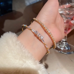 Detail of 18K gold plated bangle set with sparkling cubic zirconia on a wrist