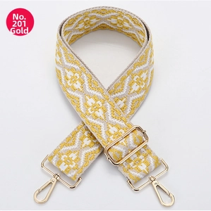 Close-up of adjustable canvas shoulder strap with yellow geometric jacquard and gold hooks