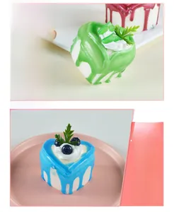 Detailed view of colorful heart-shaped miniature cake magnets with cream and fruit toppings