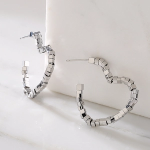 Silver geometric heart hoop earrings with cubic metal beads on white marble background