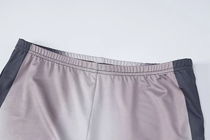 Detail of high-waisted purple gradient leggings with double-needle stitching flat lay