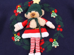 Détail du pull de Noël avec ours en peluche 3D et broderies festives élégantes