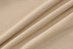 Gros plan du tissu en maille côtelée beige montrant la texture détaillée du matériau