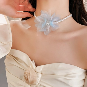 Detail of mesh flower pearl necklace with blue gradient petals on a fashion model