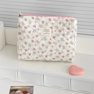 Detailed macro view of quilted makeup bag with cute gray bear and pink heart prints