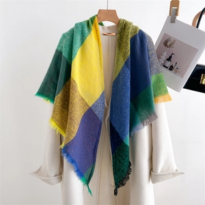 Close-up of multicolored plaid scarf with green yellow and blue tones and fringe tassels