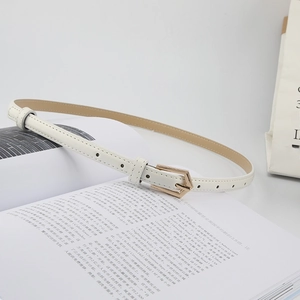 Detailed close-up of a slim white leather belt with a gold geometric metal buckle