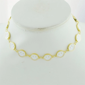 Detailed view of gold-plated necklace with white enamel smiley face charms on a neck model