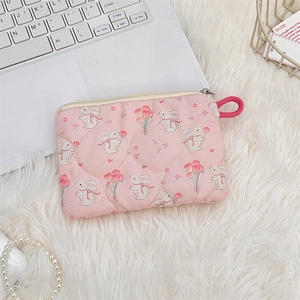 Detailed close-up of a pink quilted mini pouch with cute rabbit and floral patterns