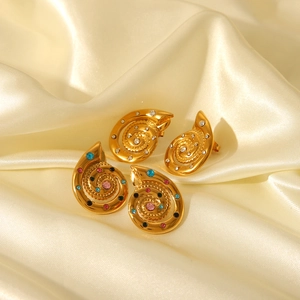 Detailed shot of gold-plated conch earrings with colorful gemstones and white rhinestones