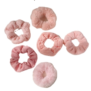 Set of six pink plush scrunchies in various textures like velvet and corduroy