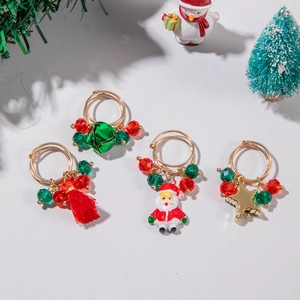 Three-piece Christmas ring set with elk, bells, and Santa pendants on grey background