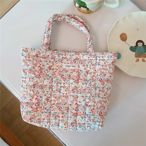 Close-up of floral quilted cotton handbag with soft texture and simple wish label