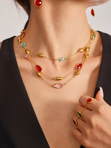 Detailed view of 18k gold plated necklace and colorful gemstone rings set on model