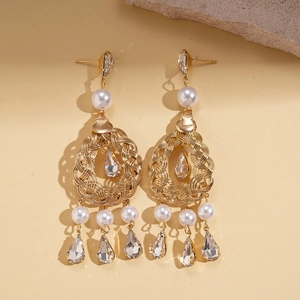 Detail of vintage gold earrings featuring white pearls and teardrop crystal pendants