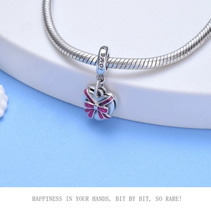 Macro shot of silver S925 charm with pink bow, LOVE engraving, and snake chain detail