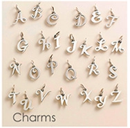 Makro-Detail von 26 Alphabet-Anhängern von A bis Z in Silber für DIY-Schmuck