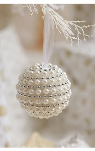 Detail of elegant white pearl Christmas ball ornament with silver beads and silk ribbon