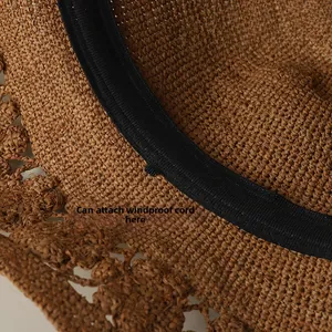 Macro shot of straw hat inner band featuring a black loop for attaching windproof cords